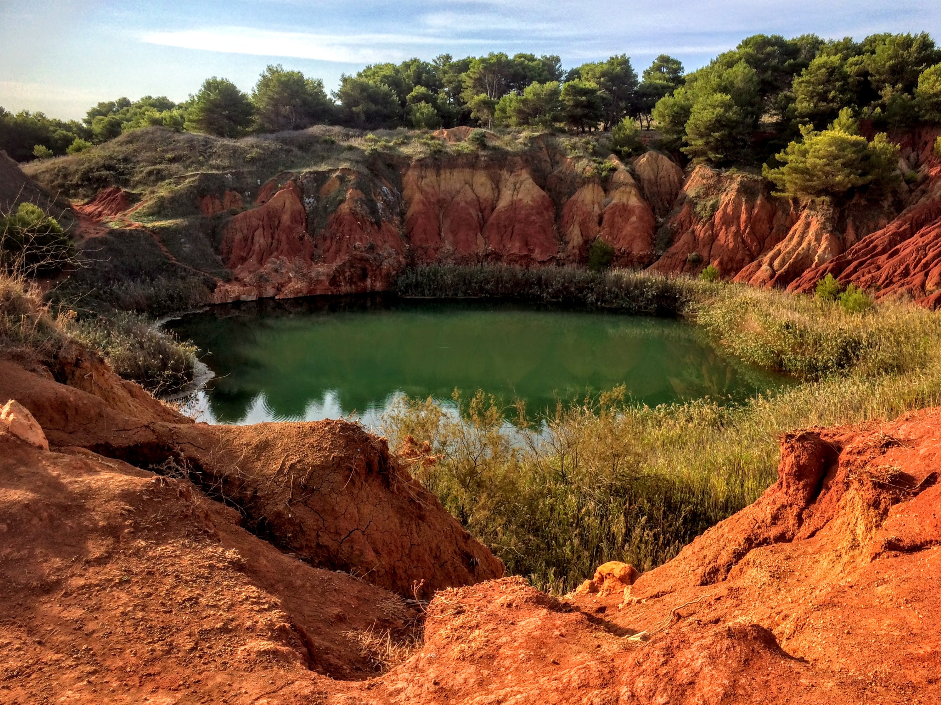 Otranto’s Bauxite Quarry: red earth, vegetation and a lake formed within the former mining site